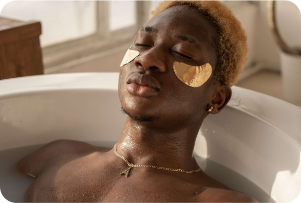 Homem em uma banheira com produtos de spa no rosto.