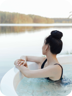 Mulher em uma banheira olhando horizonte na janela.