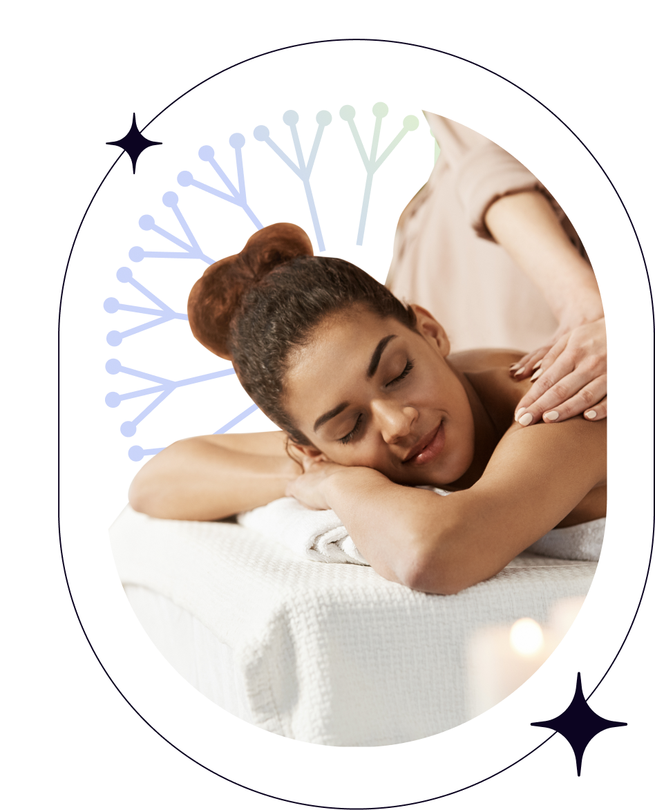 Mulher recebendo massagem deitada de bruços com a cabeça de lado sobre os braços cruzados e expressão de tranquilidade.